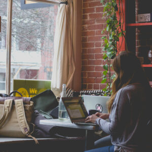 Photo of a woman in a coffee shop using a laptop