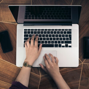 Overhead photo of hands typing on a laptop
