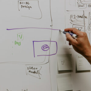 Photo of a person drawing website wireframes on a whiteboard