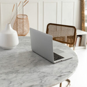 Photo of a marble table and chair with laptop sitting open